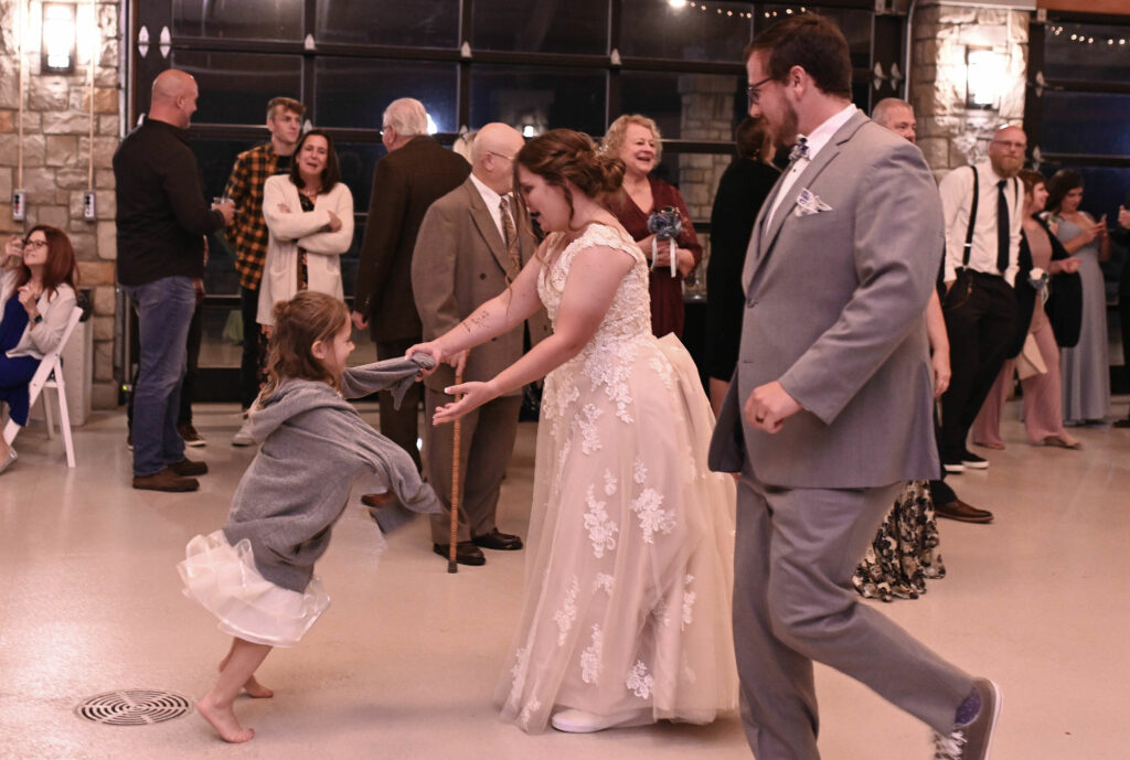 Kayge & Jayson dancing with guests at their Wedding Reception at Water's Edge Park in Powell, OH