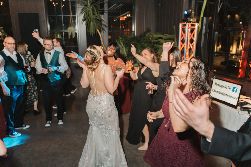 Guests gathering around Jordan at her wedding reception on the Rooftop at Seventh Son Brewing Co in Columbus, OH