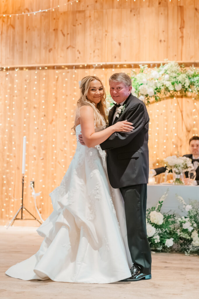 Anna & her dad sharing a dance at her wedding reception inside the Historic Barn at Jorgensen Farms