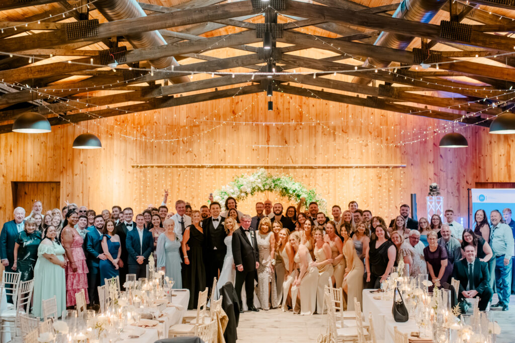 A group picture of all of Anna & Codey's guests on the dance floor at their wedding reception at Jorgensen Farms in Westerville, OH