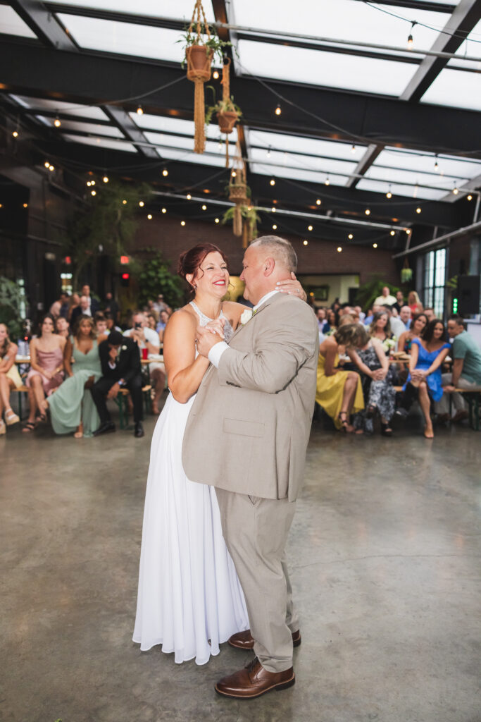 A picture of Susan & Ryan during their first dance with their guests in the background inside the Sunroom at Seventh Son Brewing in Columbus, Ohio