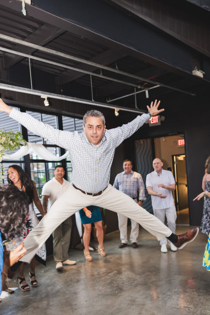 One of their guests in mid-air on the dance floor at Susan & Ryan's Wedding Reception at Seventh Son Brewing in Columbus, Ohio