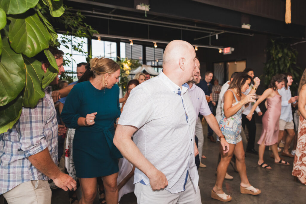Family and friends on the dance floor inside the Sunroom at Seventh Son Brewing in Columbus, Ohio for Susan & Ryan's Wedding Reception
