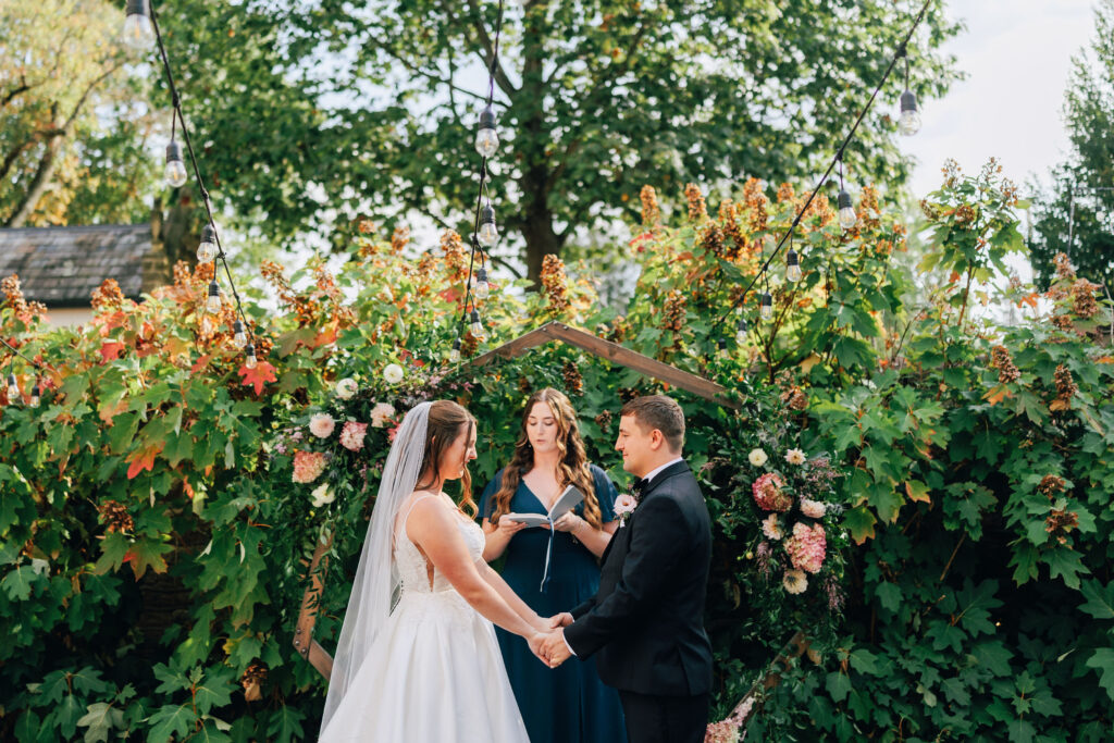 Ann & Bryse at the altar during their wedding ceremony in the Courtyard at the Granville Inn in Granville, Ohio