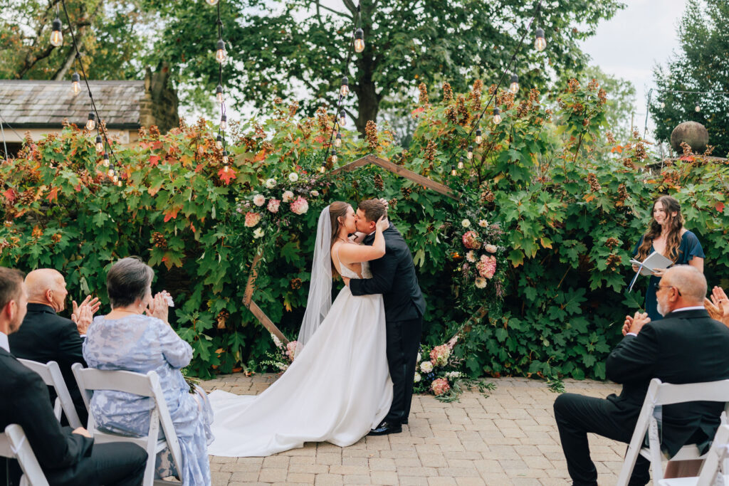 Ann & Bryse sealing their vows with a kiss during their wedding ceremony in the Courtyard of the Granville Inn in Granville, Ohio
