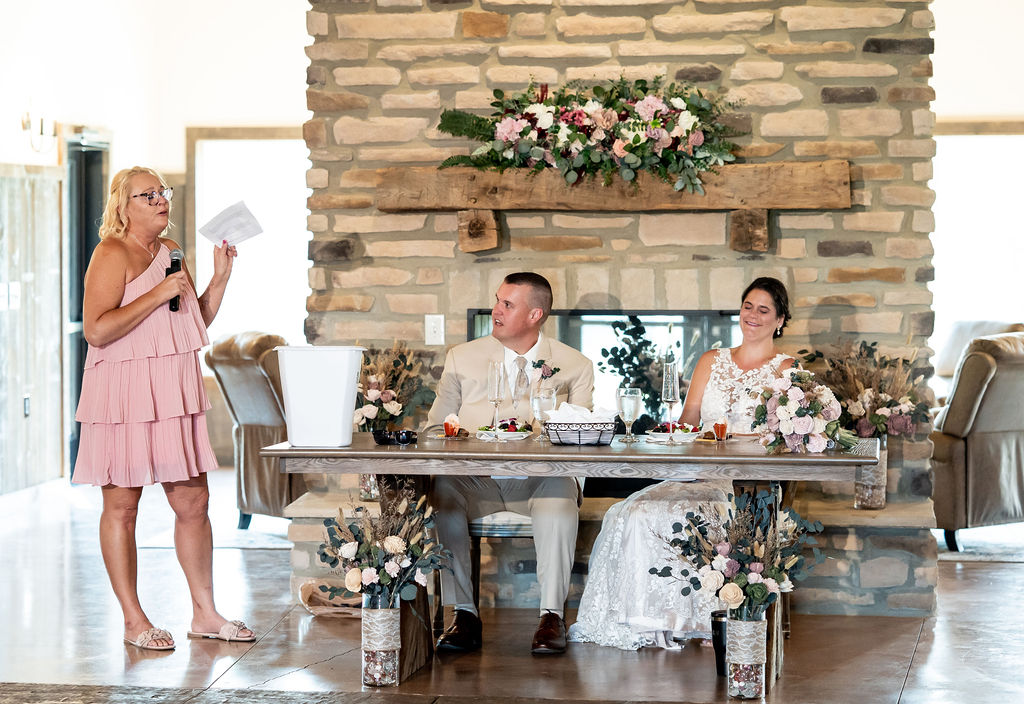 Sarah & Ryan listening to one of the speeches during their wedding reception at The Old Barns at Dry Run Farms in Williamsport, Ohio