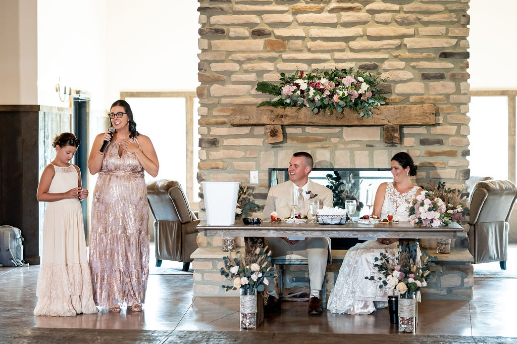 Sarah & Ryan listening to another one of the speeches before dinner at their wedding reception at The Old Barns at Dry Run Farms in Williamsport, Ohio