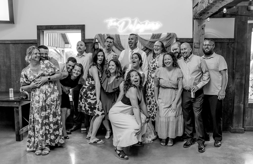 Friends and family gathered around Sarah & Ryan for a picture on their photo wall