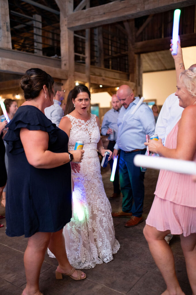 Sarah surrounded by guests on the dance floor at her wedding reception at The Old Barns at Dry Run Farms in Williamsport, Ohio