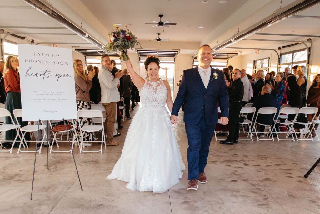 Heidi & Rusty exiting their wedding ceremony inside The Pavilion at the Wenbeck Wedding & Events Center