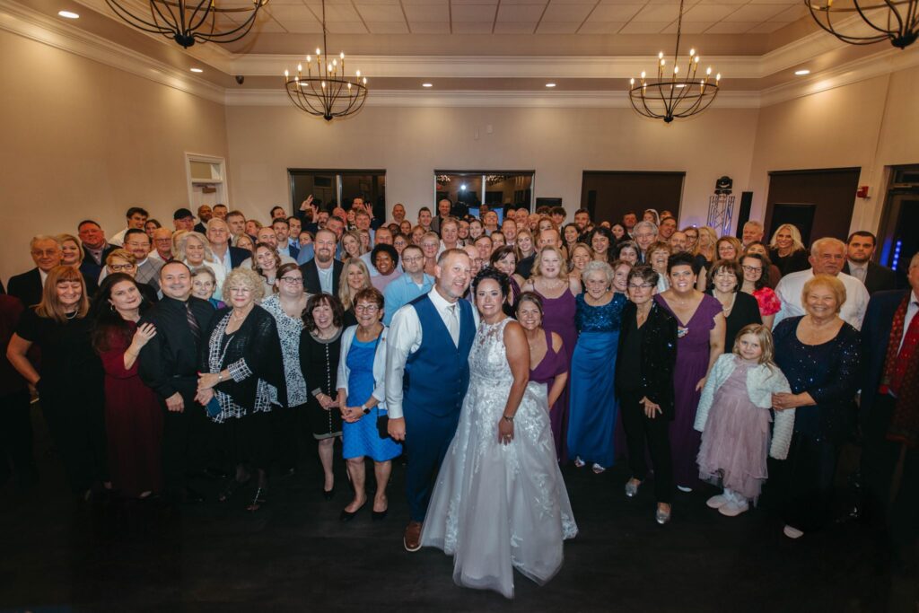 The group photo at Heidi & Rusty's Wedding Reception inside the ballroom at The Wenbeck Wedding & Events Center in Lewis Center, Ohio