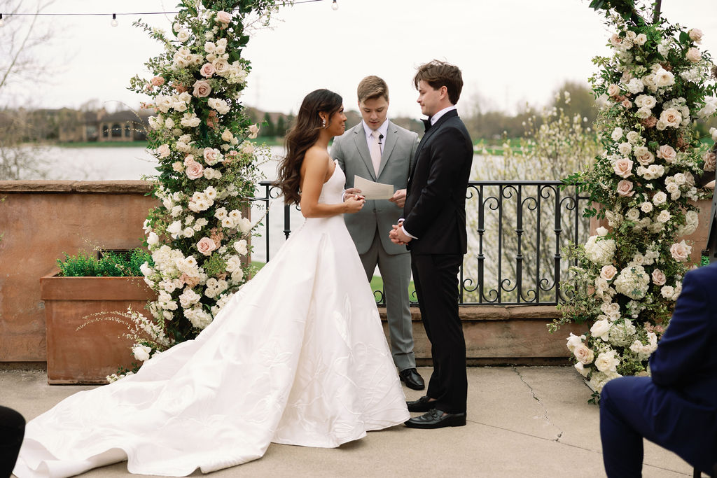 Shannon, Brady, and their officiant at the altar during their wedding ceremony overlooking the lake behind The Club at Corazon