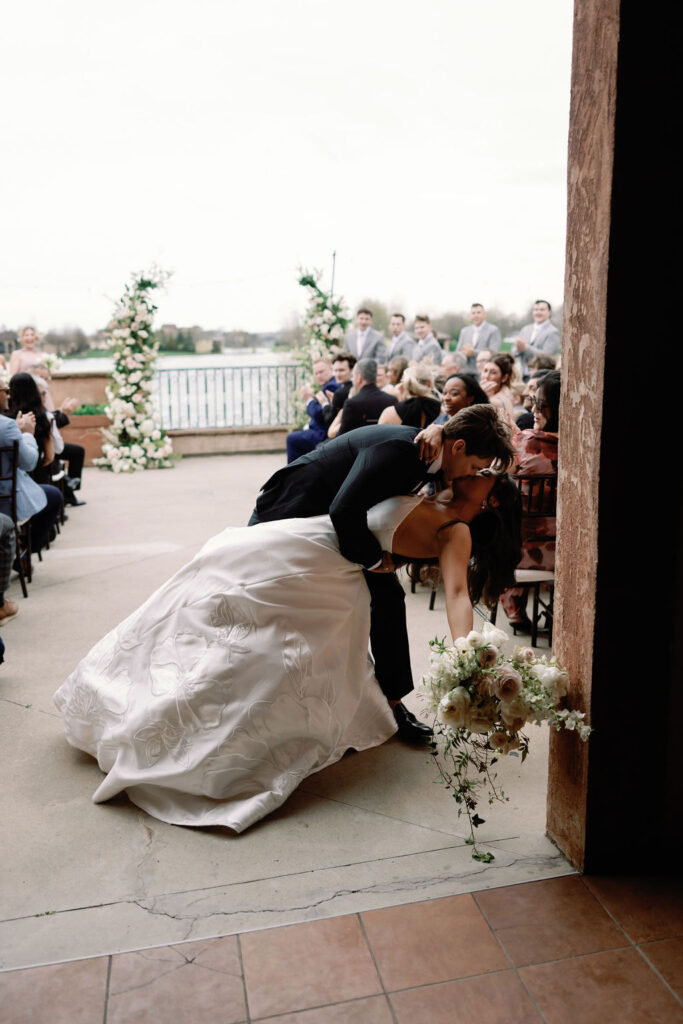 Shannon and Brady pause for a kiss during the recessional following their wedding ceremony at The Club at Corazon in Dublin, Ohio