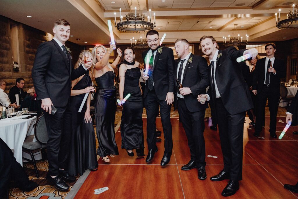 Morgan & Jonny's guests with their glow sticks on the dance floor at their wedding reception inside the Denison Room